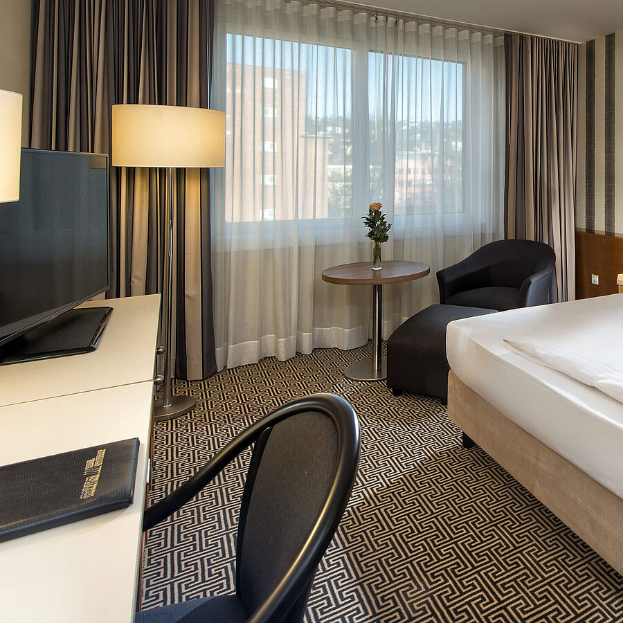 Modernes Einzelzimmer mit Schreibtisch, großem Fenster und Stadtblick im Maritim Hotel Stuttgart