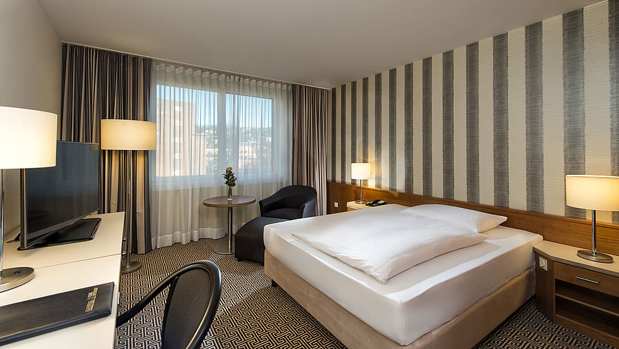 Modernes Einzelzimmer mit Schreibtisch, großem Fenster und Stadtblick im Maritim Hotel Stuttgart