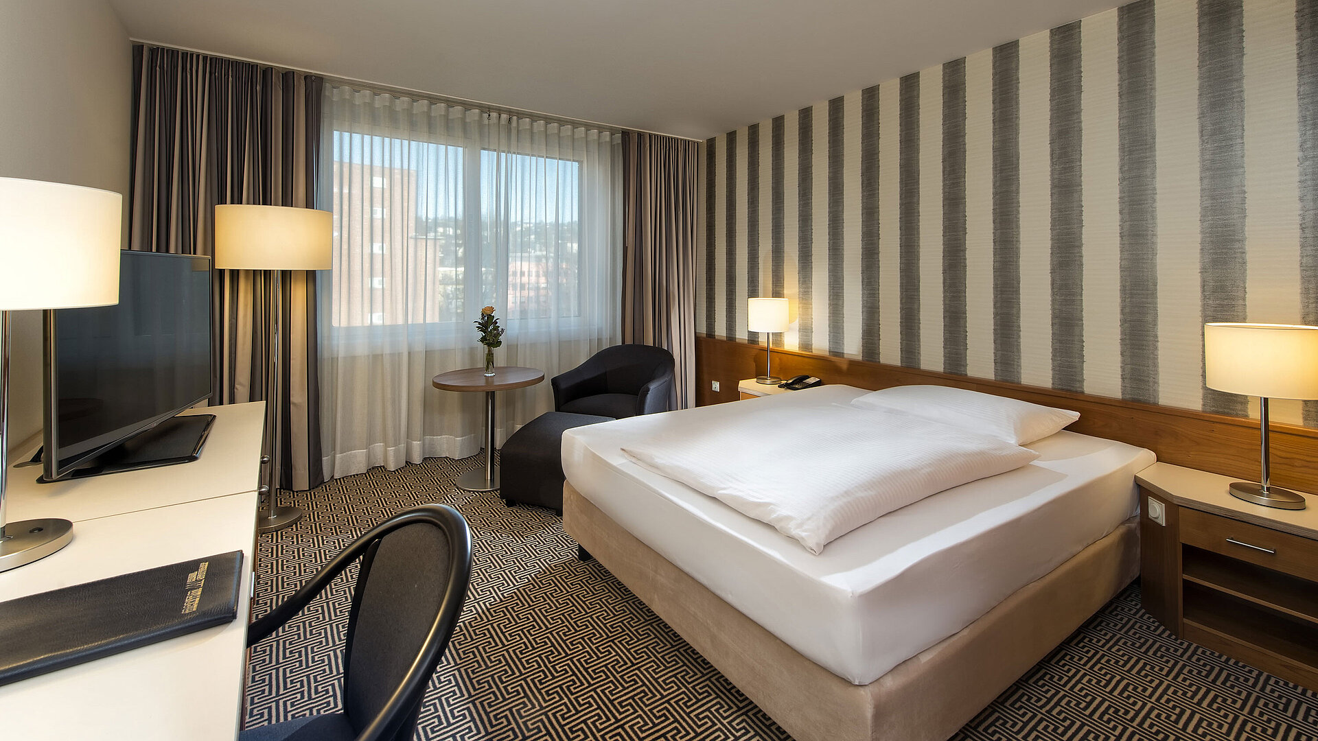 Modernes Einzelzimmer mit Schreibtisch, großem Fenster und Stadtblick im Maritim Hotel Stuttgart
