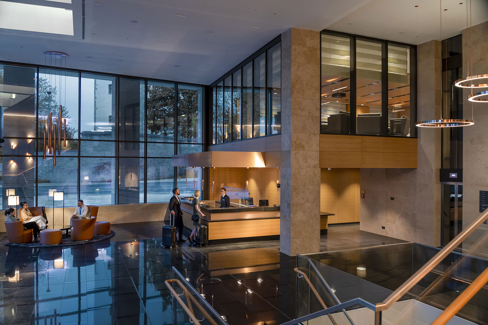 Rezeption Die moderne Lobby des Maritim Hotel Ingolstadt mit hohen Glasfenstern, Rezeption und gemütlichen Sitzbereichen.