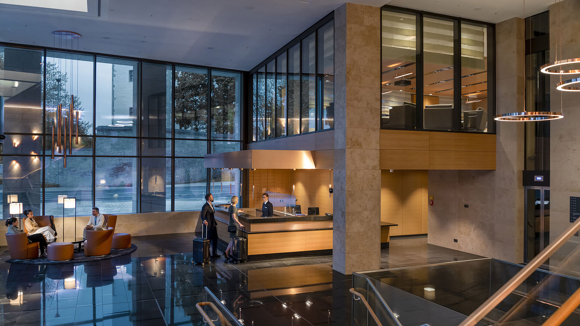 Die moderne Lobby des Maritim Hotel Ingolstadt mit hohen Glasfenstern, Rezeption und gemütlichen Sitzbereichen.
