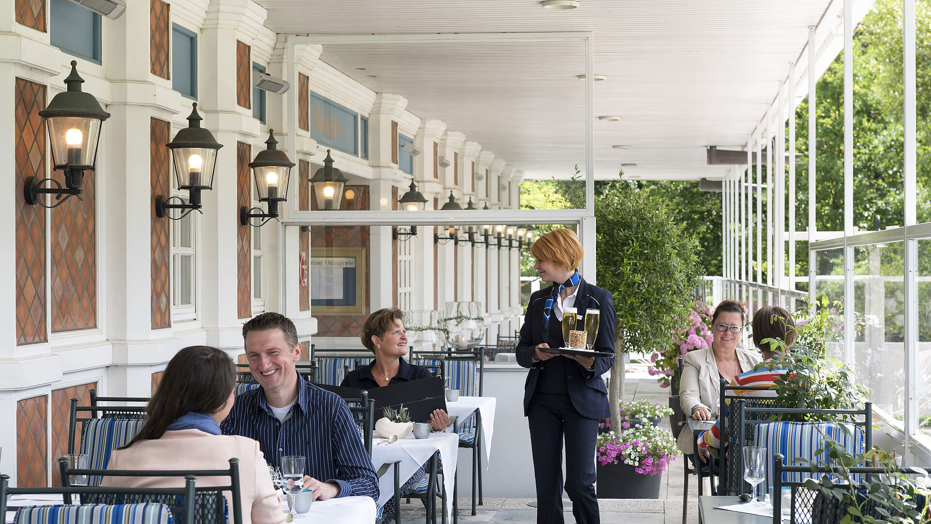 Gäste auf der Terrasse der Friesenstube im Maritim Seehotel Timmendorfer Strand beim Essen und Trinken.