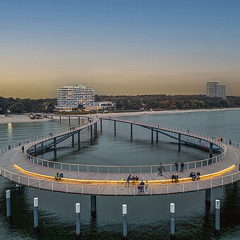 Beleuchtete Seebrücke bei Abenddämmerung vor dem Maritim Seehotel Timmendorfer Strand.