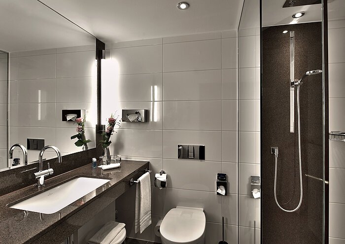 Modernes Badezimmer im Maritim Hotel Köln mit Badewanne, großer Spiegel und stilvoller Beleuchtung in neutralen Tönen.