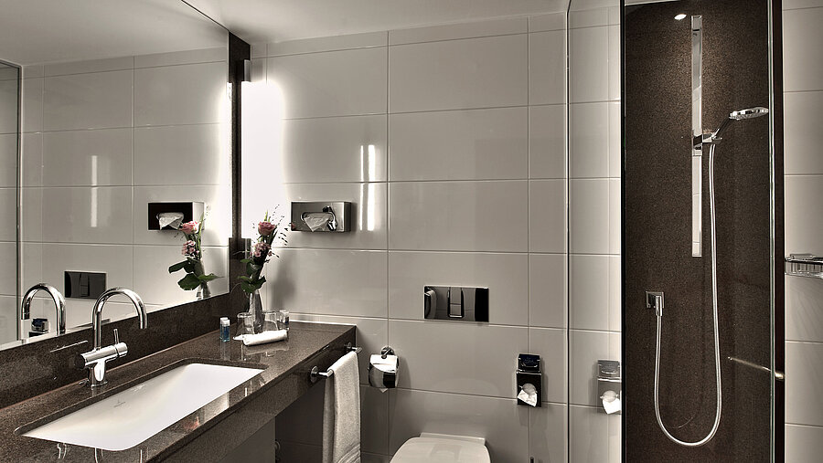 Modernes Badezimmer im Maritim Hotel Köln mit Badewanne, großer Spiegel und stilvoller Beleuchtung in neutralen Tönen.