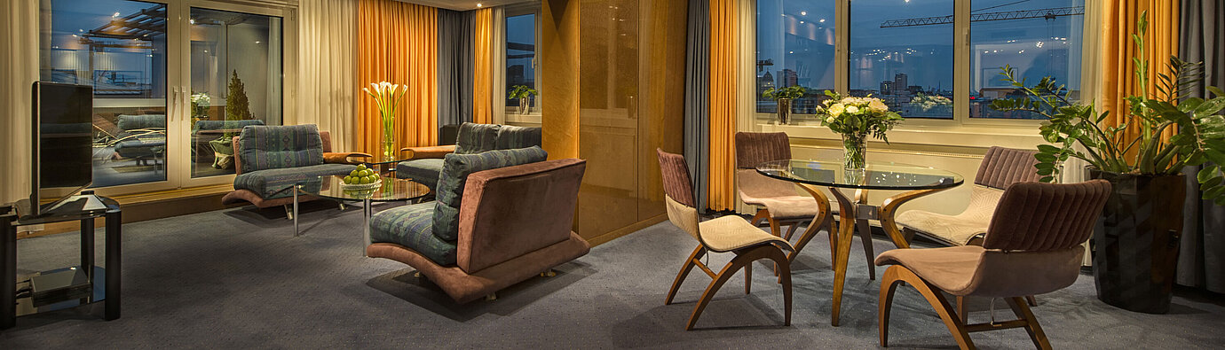 Elegantes Wohnzimmer in der Präsidenten-Suite im Maritim proArte Hotel Berlin mit stilvoller Beleuchtung und Aussicht.