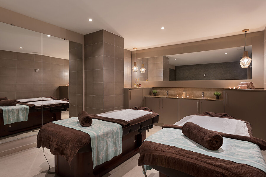 Eleganter Spa-Bereich im Maritim Antonine Hotel & Spa Malta mit zwei Massageliegen, warmem Ambiente und entspannender Wohlfühlatmosphäre.