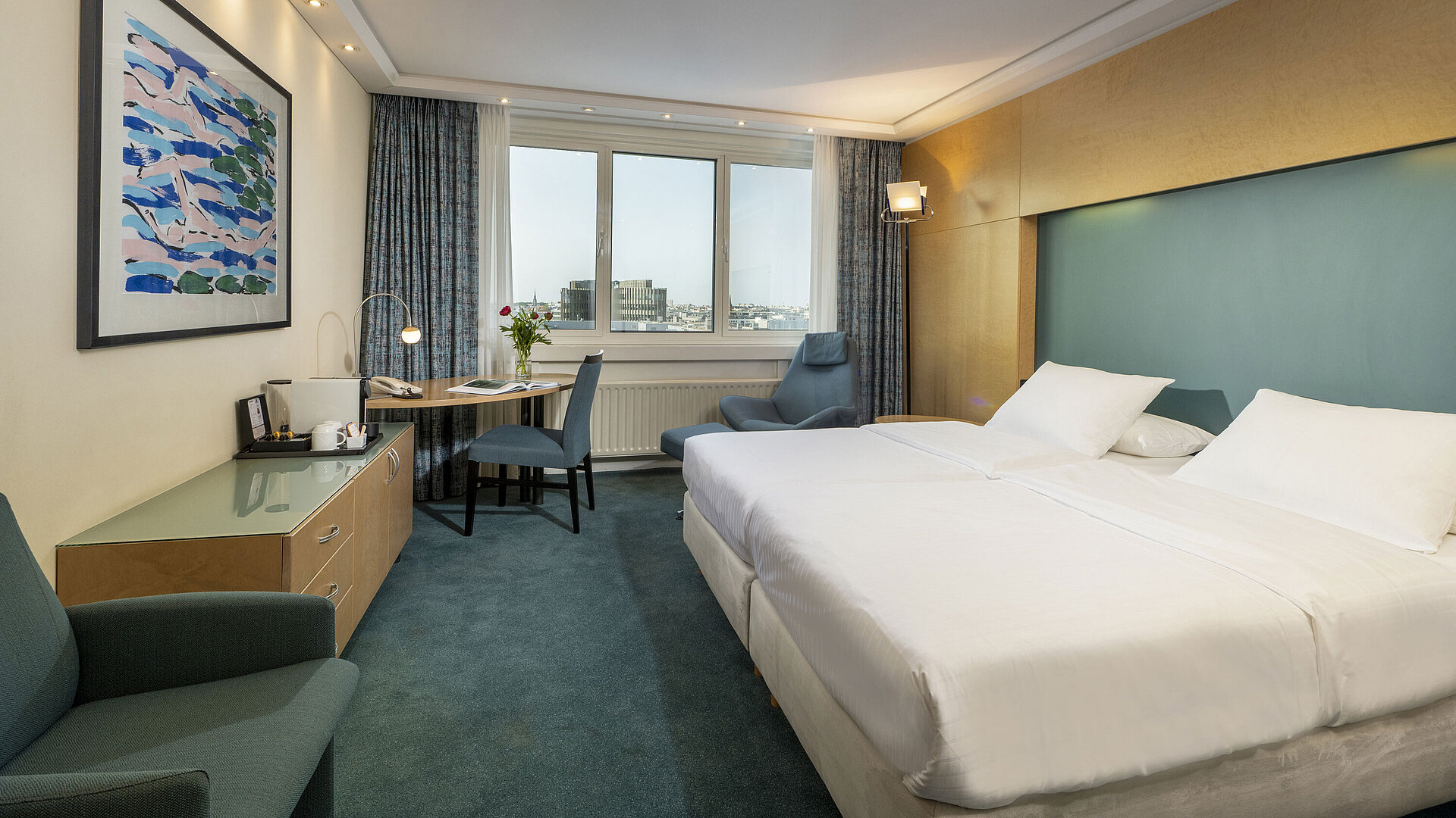 Modern eingerichtetes Superior-Zimmer im Maritim proArte mit großem Bett, Schreibtisch, Kunstwerk und Blick auf die Stadt.
