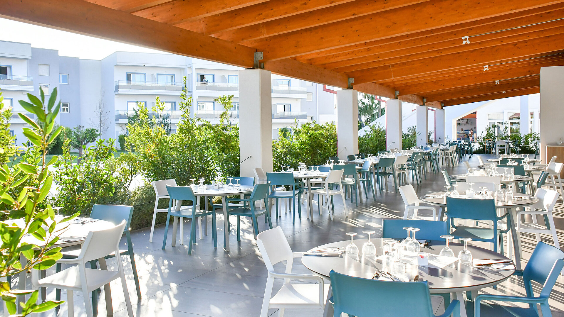Lichter, überdachter Außenbereich des Restaurants im Maritim Resort Calabria mit gedeckten Tischen
