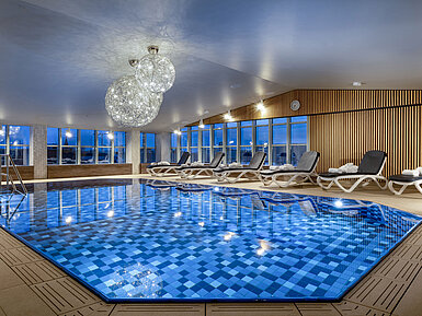 Wellnessbereich mit Liegen und Schwimmbad im Maritim Hotel München