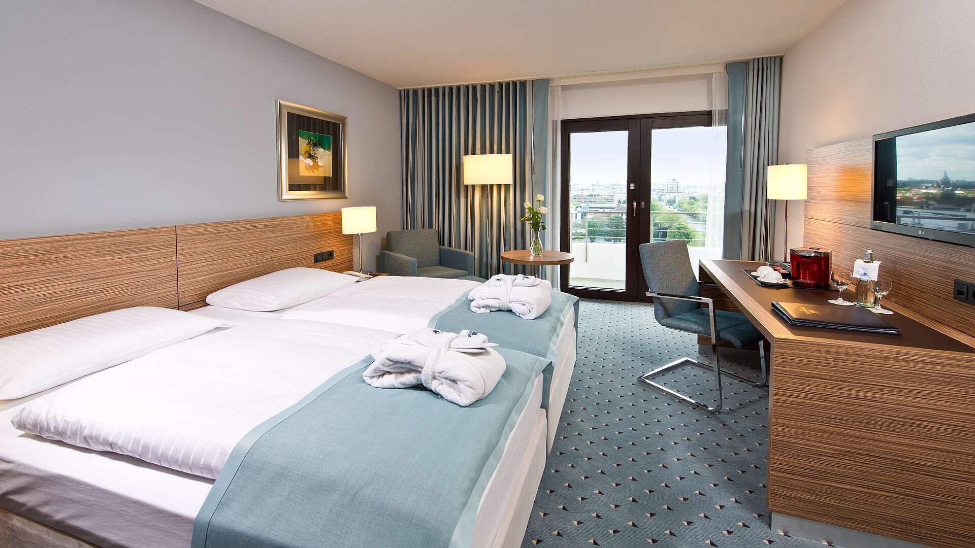 Superior Zimmer im Maritim Hotel Darmstadt mit stilvollem Design, Schreibtisch, Sitzecke und Doppelbett mit Bademänteln.