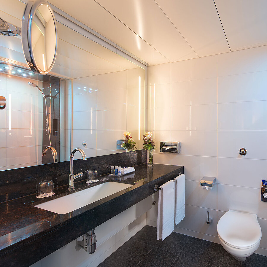 Geräumiges Bad mit Dusche, WC, Spiegel und Granitwaschtisch im Maritim Hotel Stuttgart