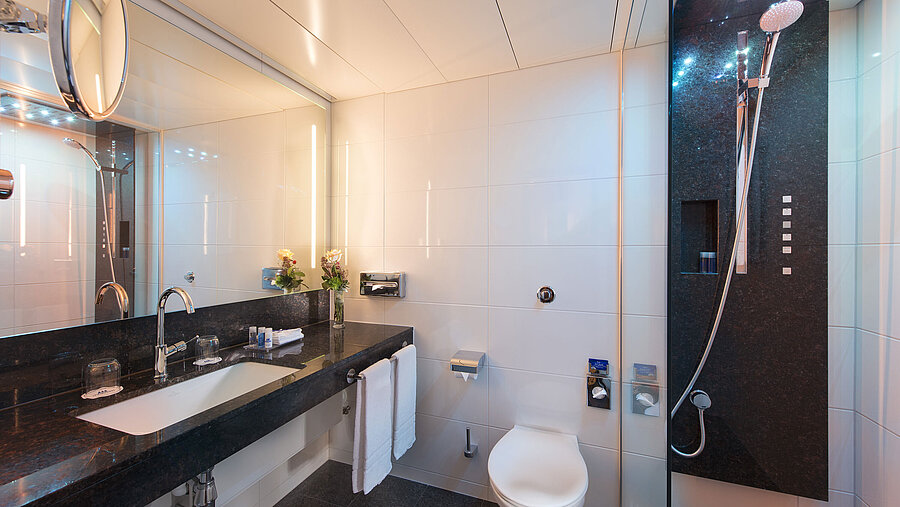 Geräumiges Bad mit Dusche, WC, Spiegel und Granitwaschtisch im Maritim Hotel Stuttgart