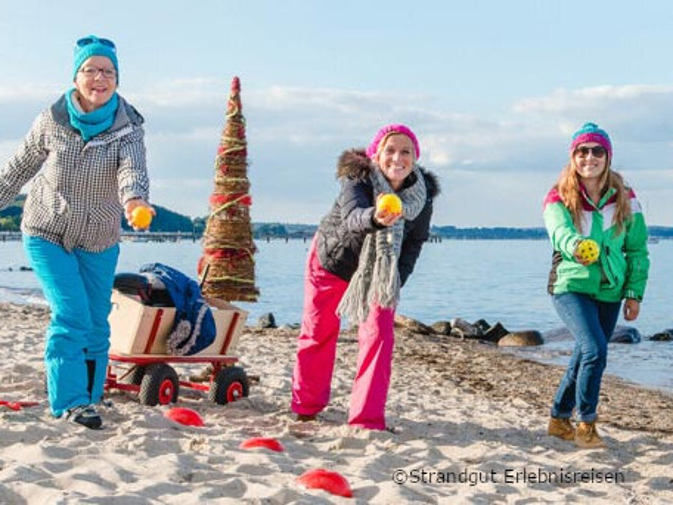 Winterliches Strandbosseln Drei Frauen stehen am winterlichen Ostseestrand und werfen mit Bossel Kugeln.