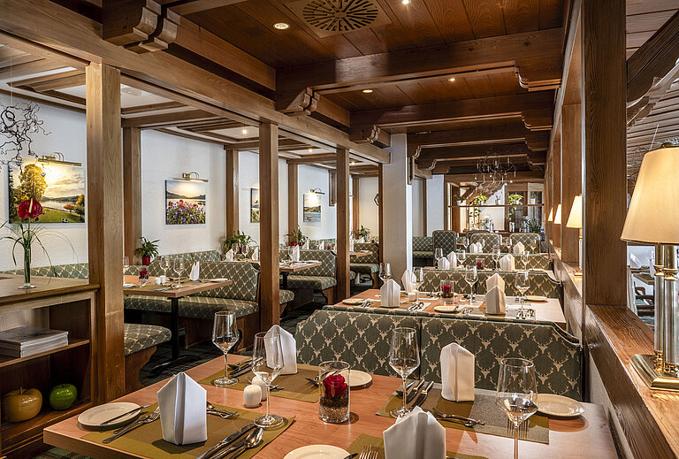 Gemütliches Restaurant mit Holzdecke und stilvoll gedeckten Tischen im Maritim Hotel Titisee