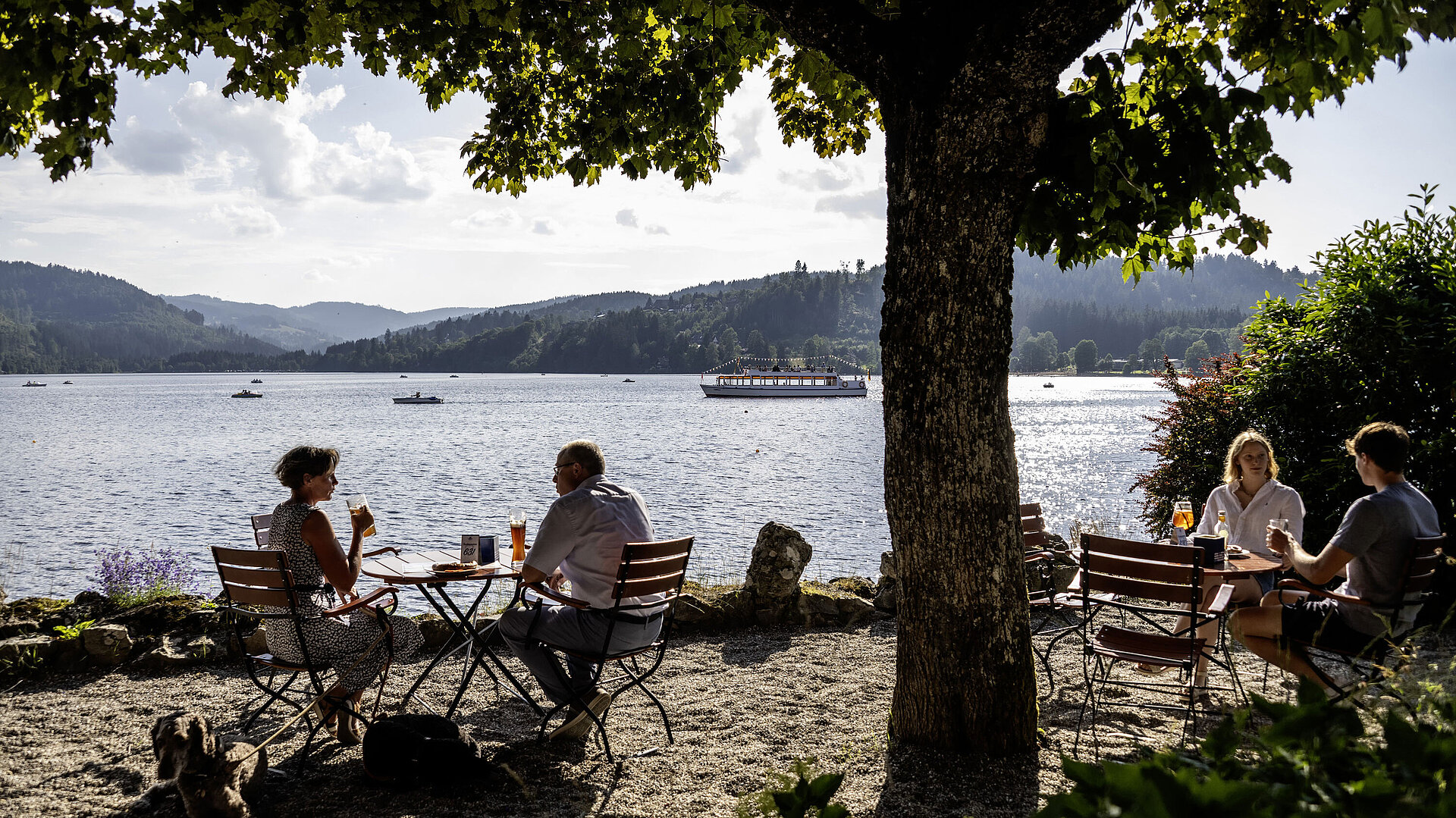 Biergarten Gäste entspannen im Biergarten des Maritim Hotel Titisee mit Blick auf den See und die Berge
