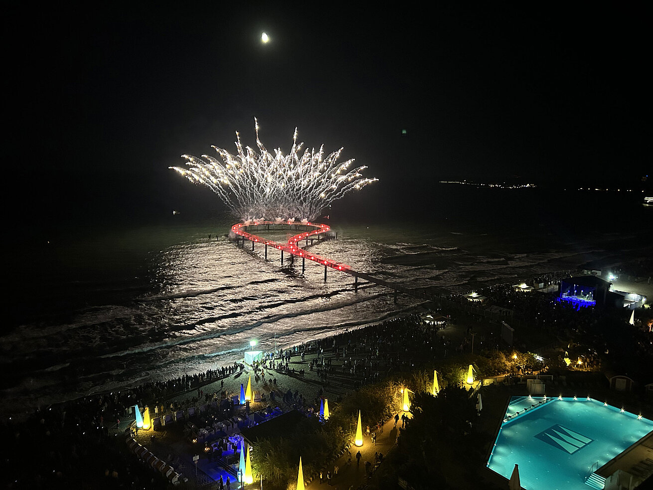 Feuerwerk Maritim Seebrücke Spektakuläres Feuerwerk über der Seebrücke am Maritim Seehotel Timmendorfer Strand bei Nacht mit Pool und feiernden Gästen.