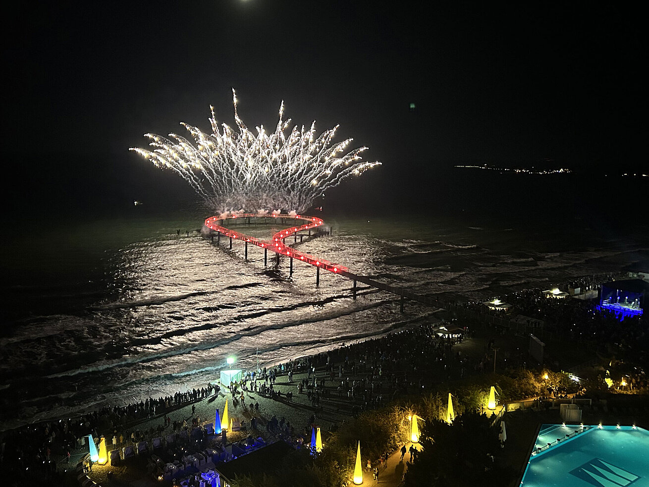 Feuerwerk Maritim Seebrücke Spektakuläres Feuerwerk über der Seebrücke am Maritim Seehotel Timmendorfer Strand bei Nacht mit Pool und feiernden Gästen.
