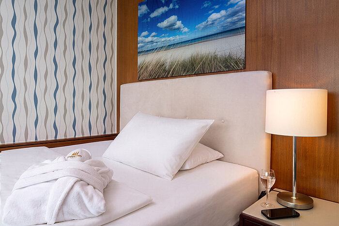 Superior Queen Zimmer Queensize-Bett im Superior Queen Zimmer mit Nachttischlampe und Bademantel