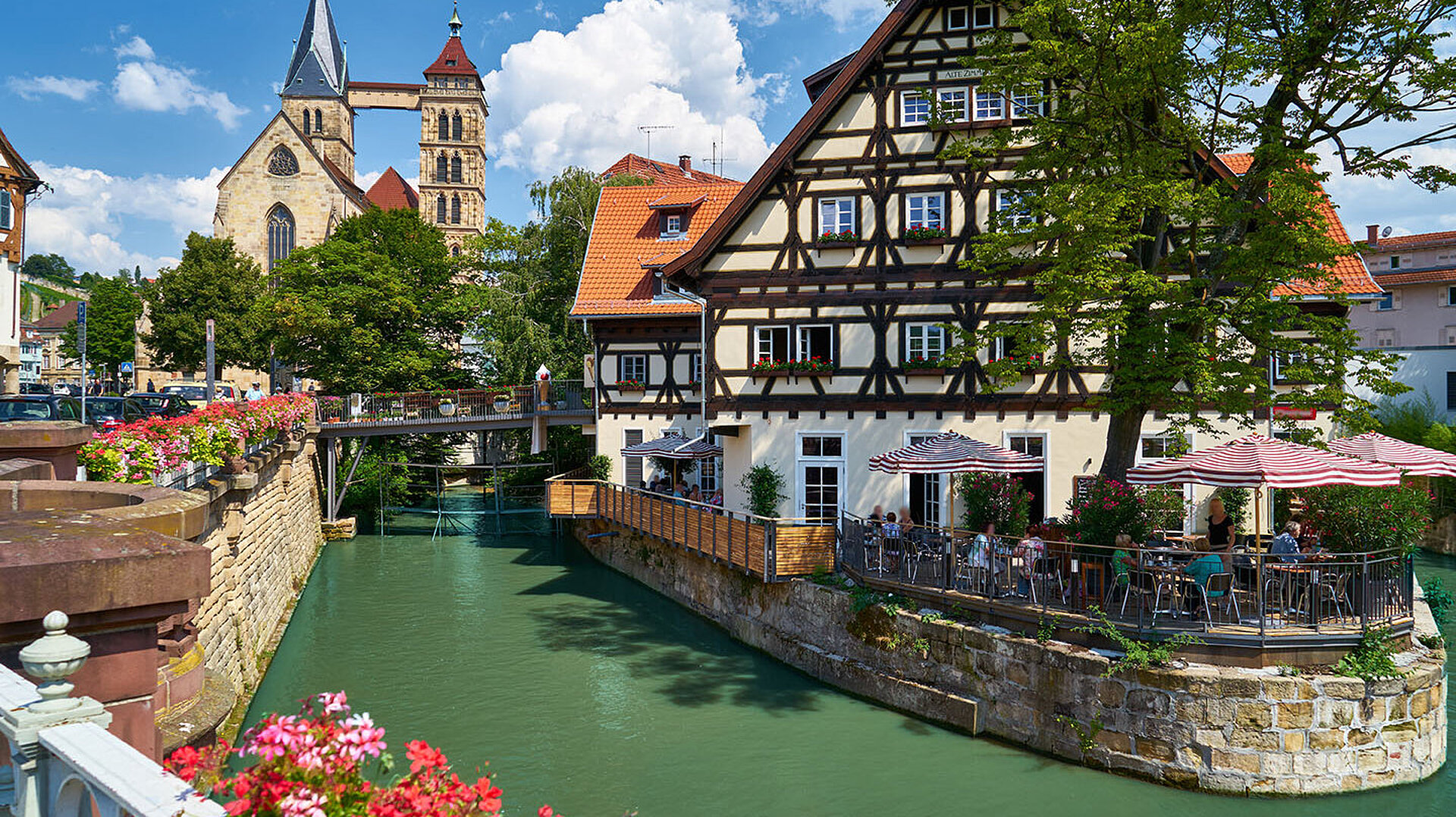Historisches Fachwerkhaus in Esslingen am Neckar mit Wasserlauf, Blumen und Altstadtkulisse