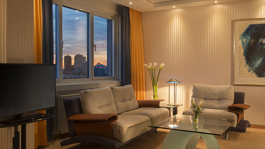 Sitzecke mit Ausblick in der Kuckei-Suite im Maritim proArte Hotel Berlin bei Sonnenuntergang.
