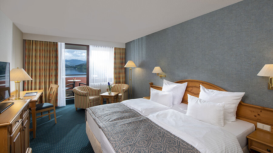 Geräumiges Zimmer im Maritim TitiseeHotel mit Sitzgruppe und Blick auf den Titisee