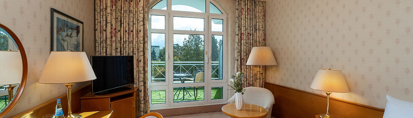 Superior Einzelzimmer mit Bett, Schreibtisch, großem Fenster, Balkonblick und klassischer Einrichtung.