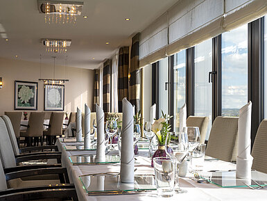 Elegante Tischdekoration in der VIP-Lounge des Maritim Hotel Düsseldorf mit großen Fenstern und stilvollem Ambiente.