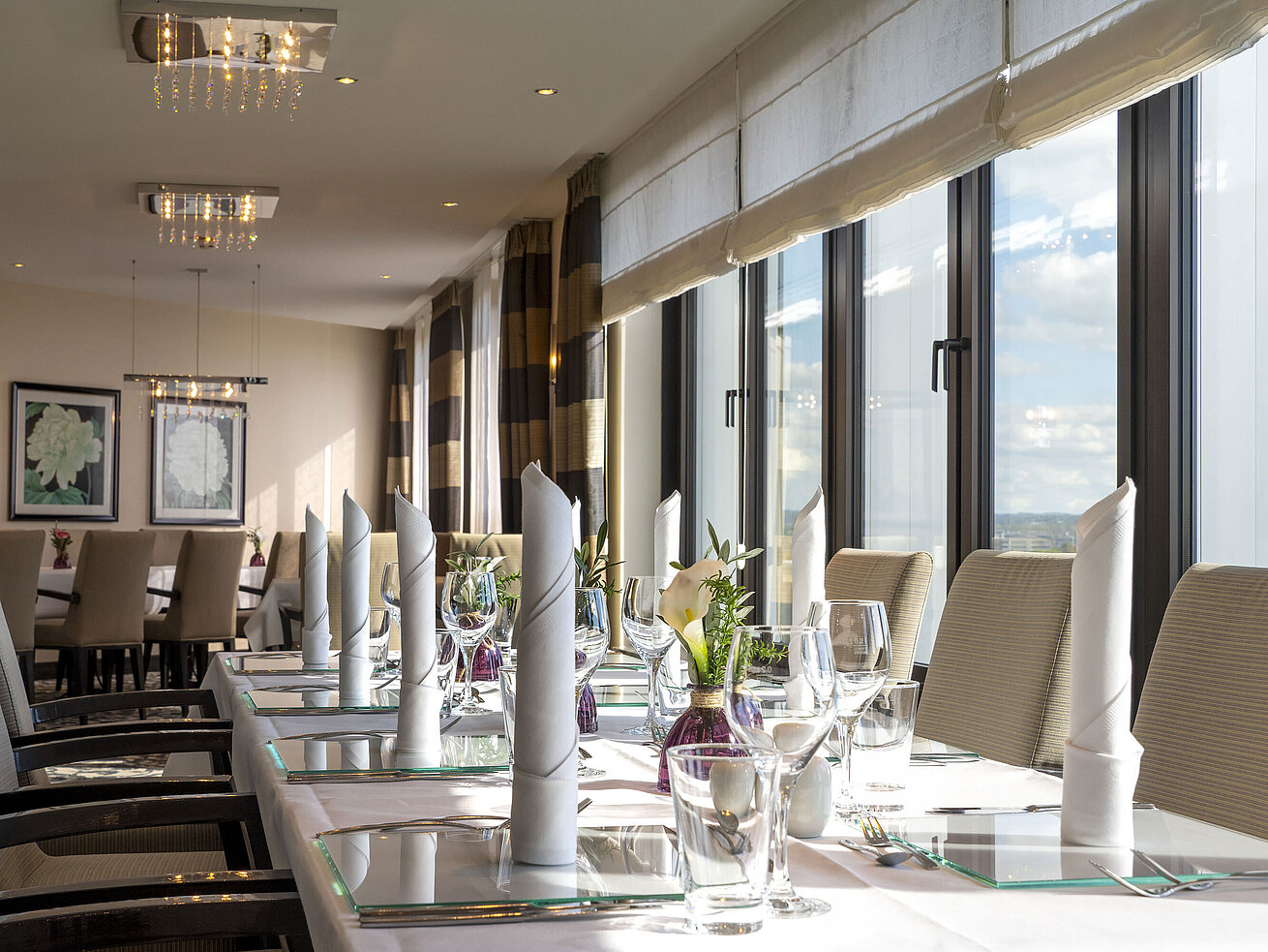 Elegante Tischdekoration in der VIP-Lounge des Maritim Hotel Düsseldorf mit großen Fenstern und stilvollem Ambiente.