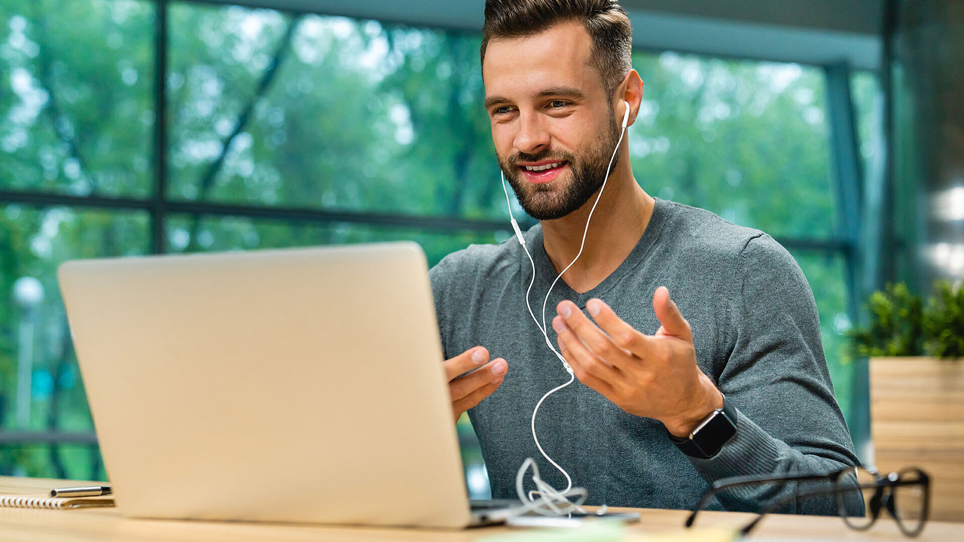 Mann führt ein Videomeeting am Laptop mit Kopfhörern