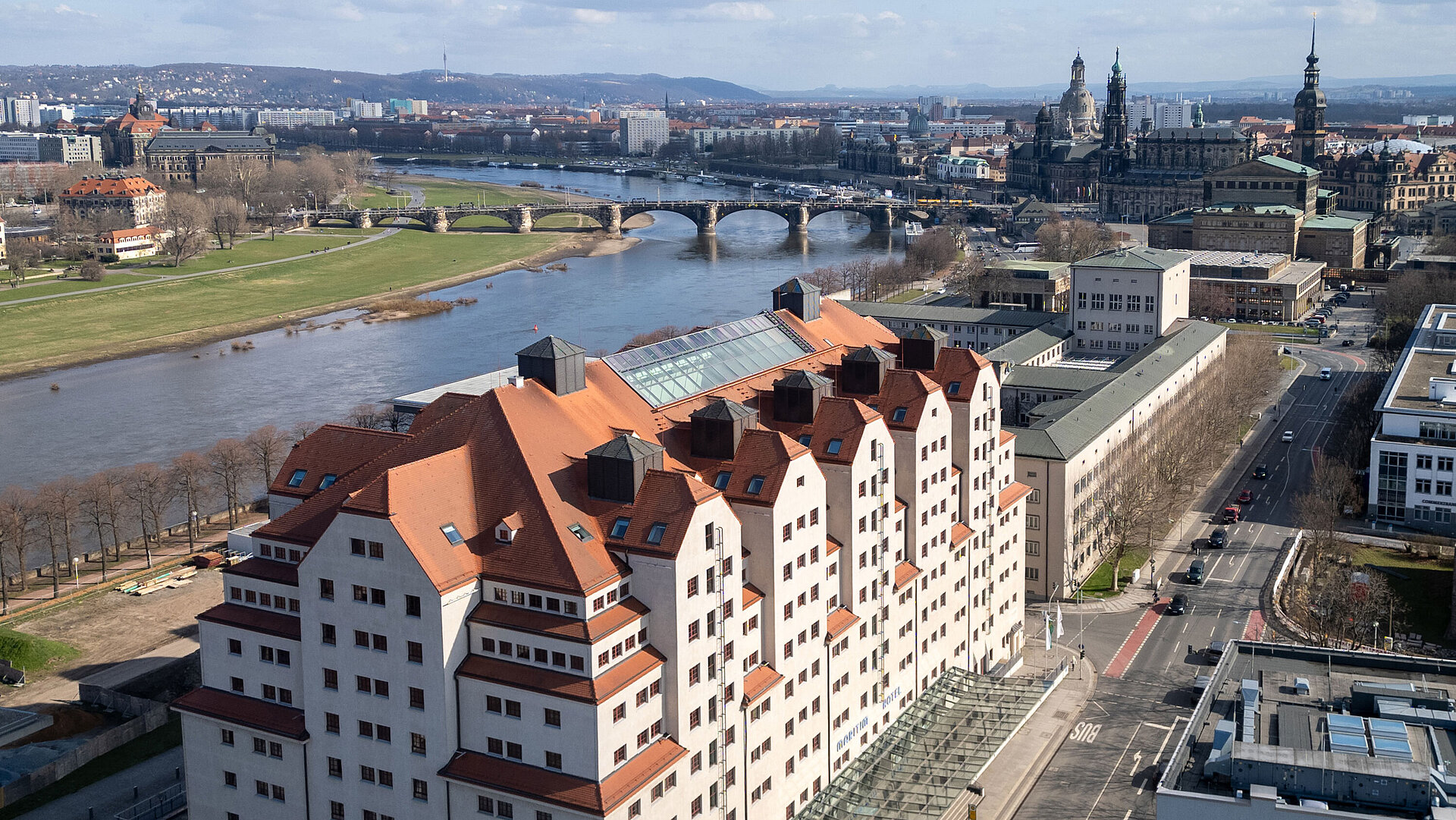 Außenansicht des Maritim Hotel Dresden mit charakteristischer Architektur direkt an der Elbe und Blick auf die Altstadt.
