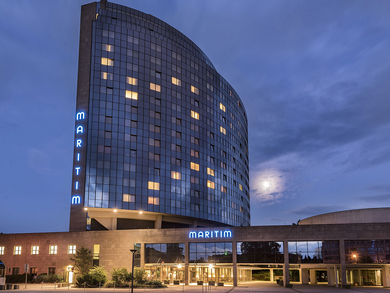 Modernes Maritim Hotel Ulm bei Nacht mit beleuchtetem Eingangsbereich und markanter Glasfassade