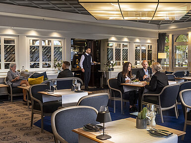 Lounge Restaurant Elegantes Restaurant mit Gästen, die speisen und entspannen. Moderne Einrichtung und große Fenster mit Ausblick.