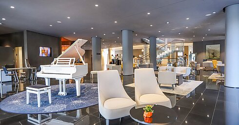 Elegante Hotellobby mit weißem Flügel und stilvollen Sitzgruppen im Maritim Hotel Plaza Tirana