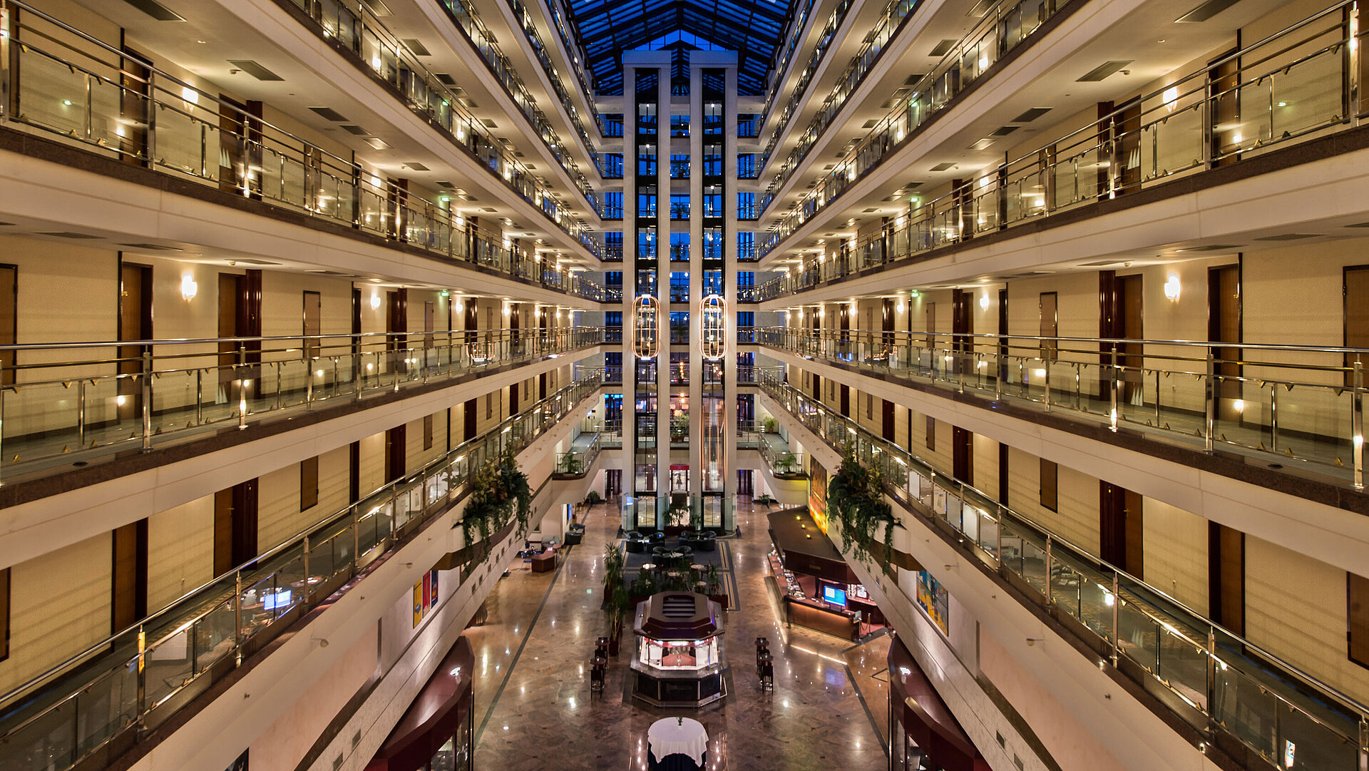 Hotelfoyer Die großzügige, helle Lobby des Maritim Hotels mit beleuchteten Etagen und moderner Architektur bei Nacht.