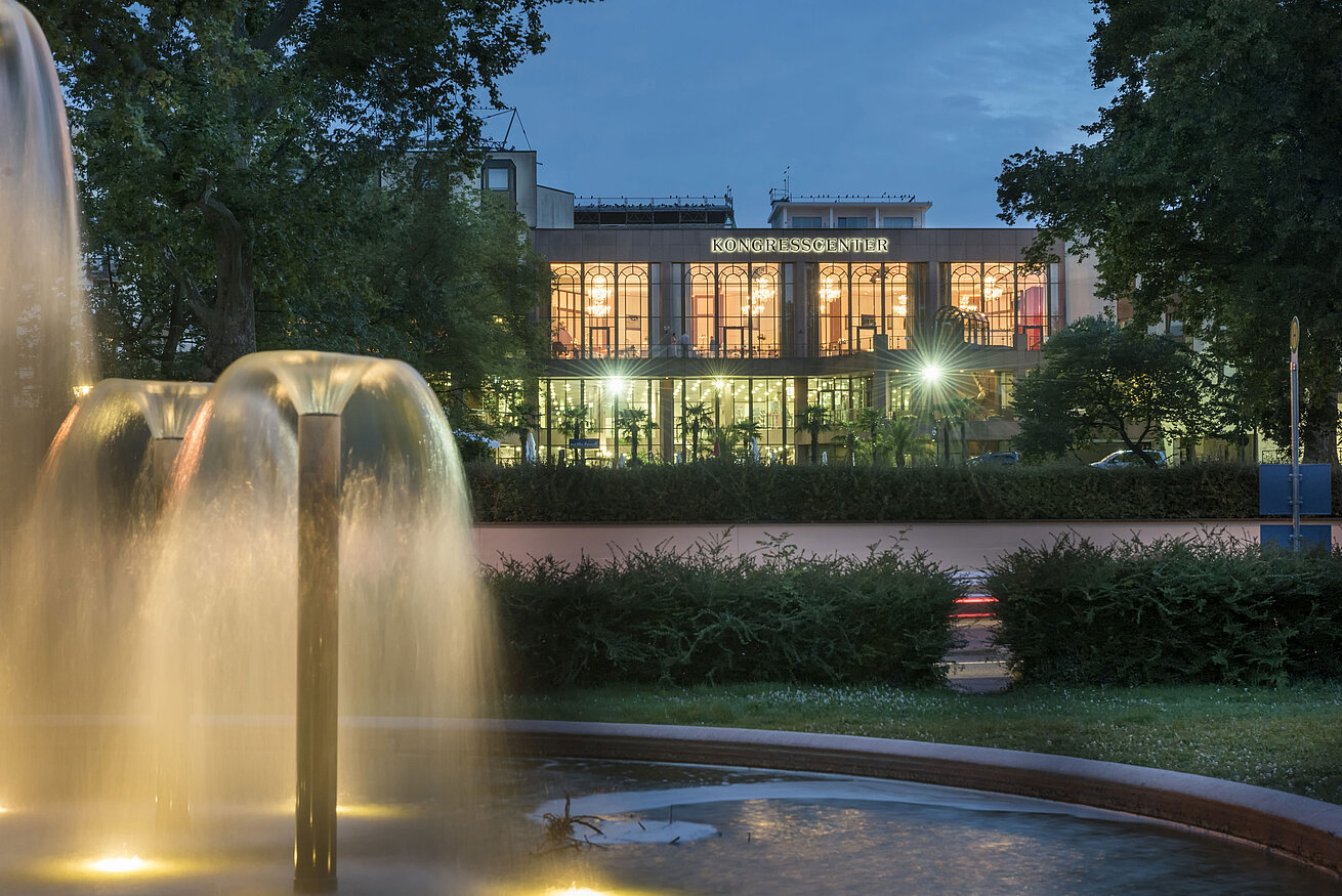 Stimmungsvolle Abendaufnahme des Kongresscenters im Maritim Hotel Bad Homburg mit beleuchtetem Brunnen.