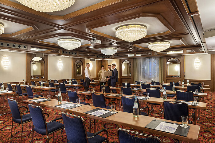 Der Saal Köln mit eleganten Kronleuchtern und Sitzreihen in einem klassischen Tagungsraum-Ambiente, bereit für eine Konferenz