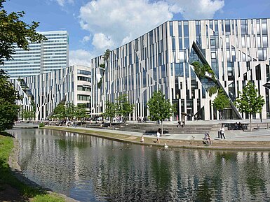 Kö-Bogen in Düsseldorf mit moderner Architektur, begrünter Fassade und Wasserlauf im urbanen Umfeld