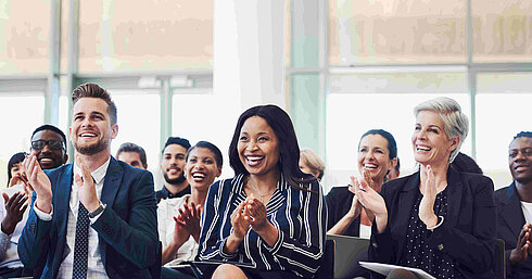 Teilnehmer applaudieren bei Konferenz oder Seminar im Tagungsraum