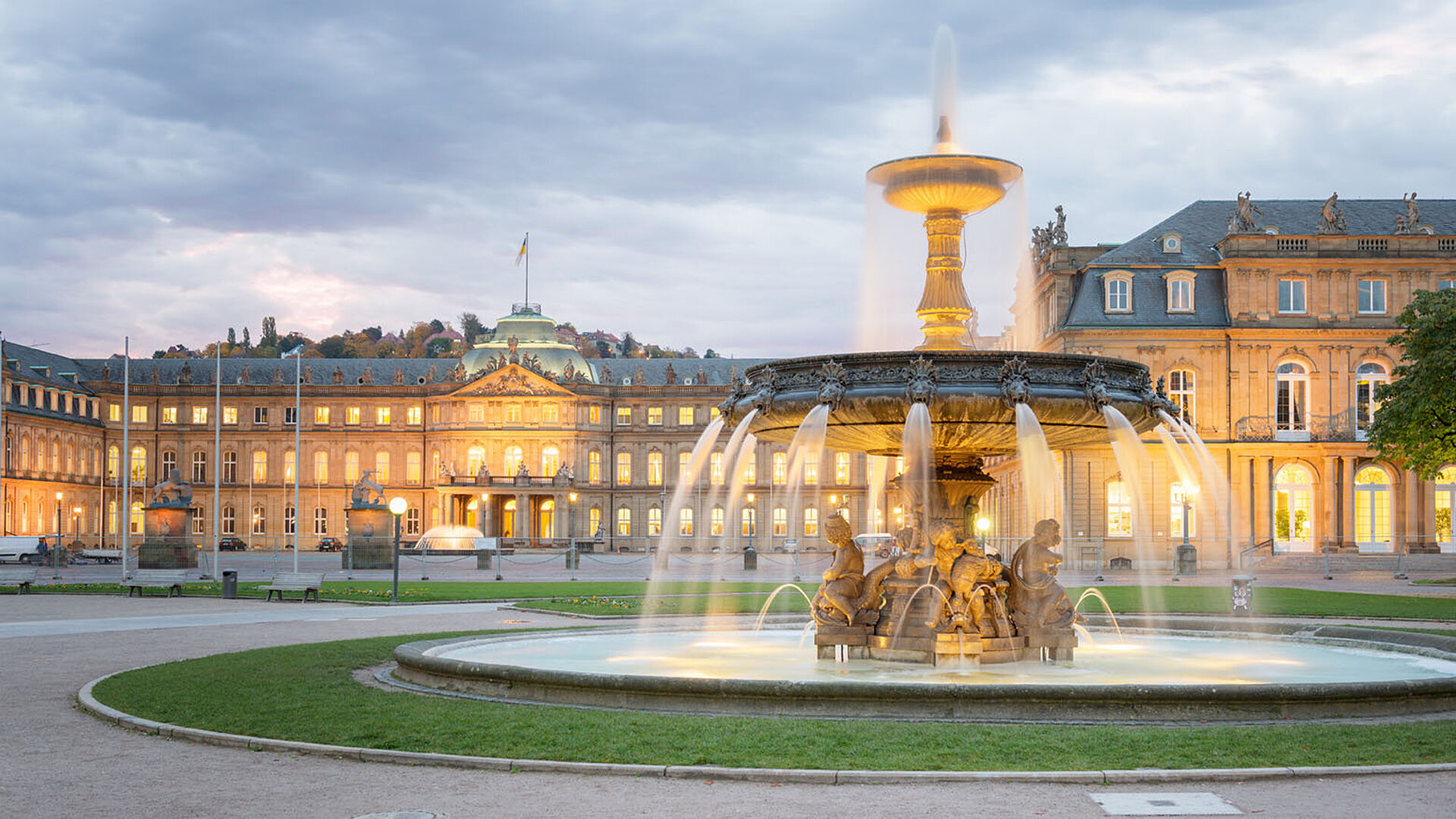 Schlossplatz in Stuttgart mit Jubiläumssäule, Springbrunnen und dem Neuen Schloss im Hintergrund.
