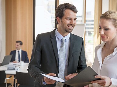 Geschäftsleute besprechen Unterlagen bei einem Meeting im Hotel.