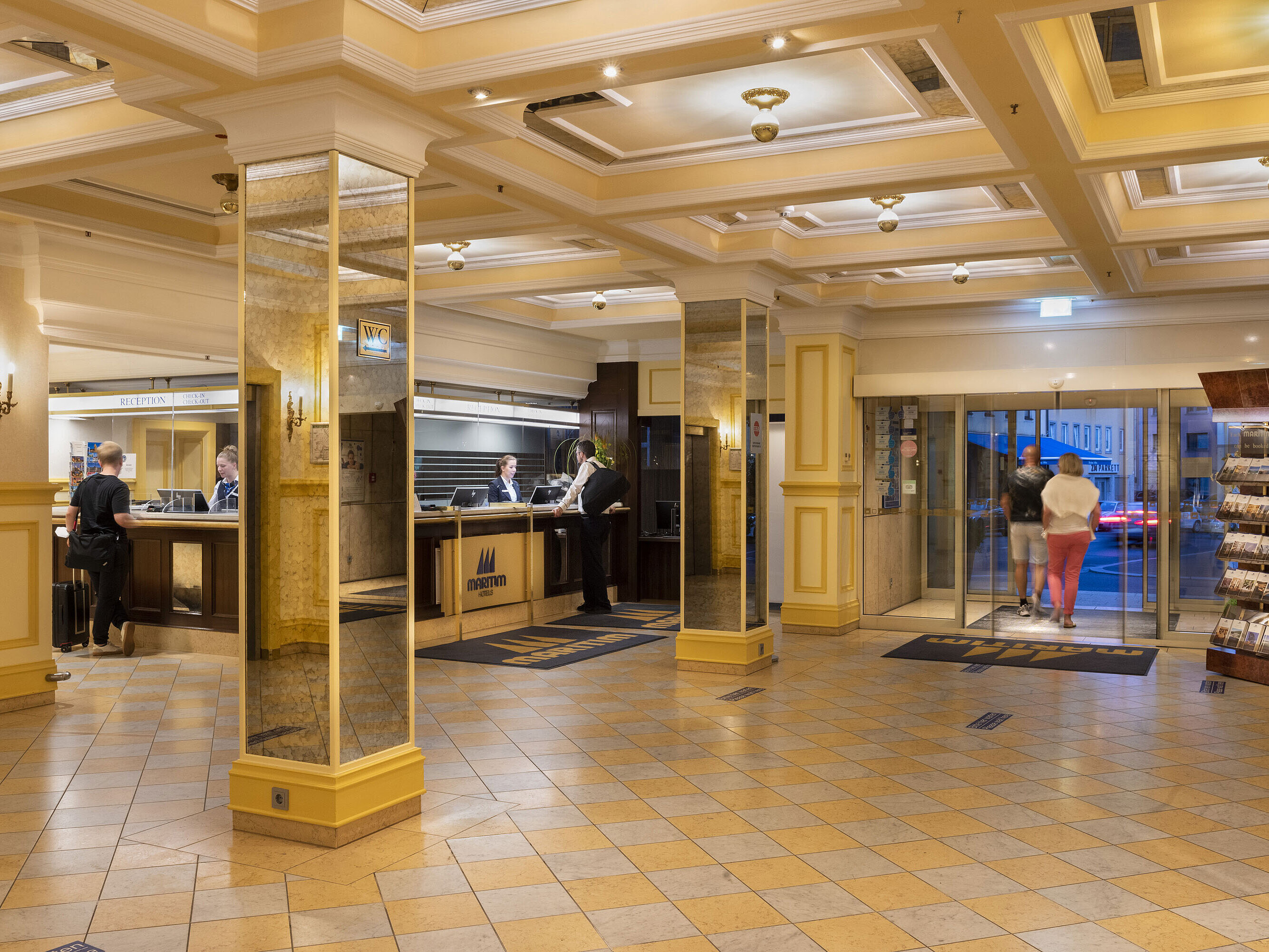 Elegante Lobby im Maritim Hotel Würzburg mit Rezeption, Spiegelwänden und Gästen beim Ein- und Auschecken
