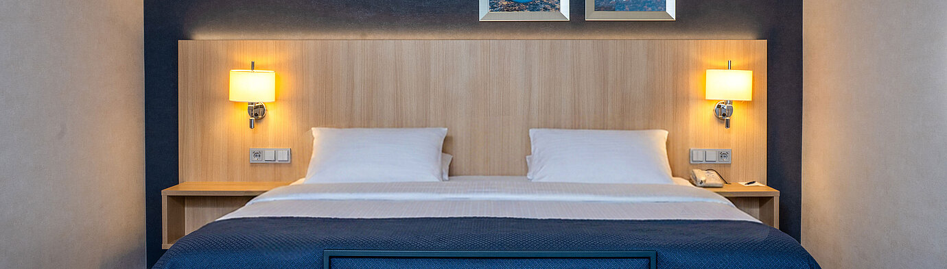 Doppelbett im Superior Familienzimmer des Maritim Hotel Würzburg mit modernem Design und gemütlicher Beleuchtung