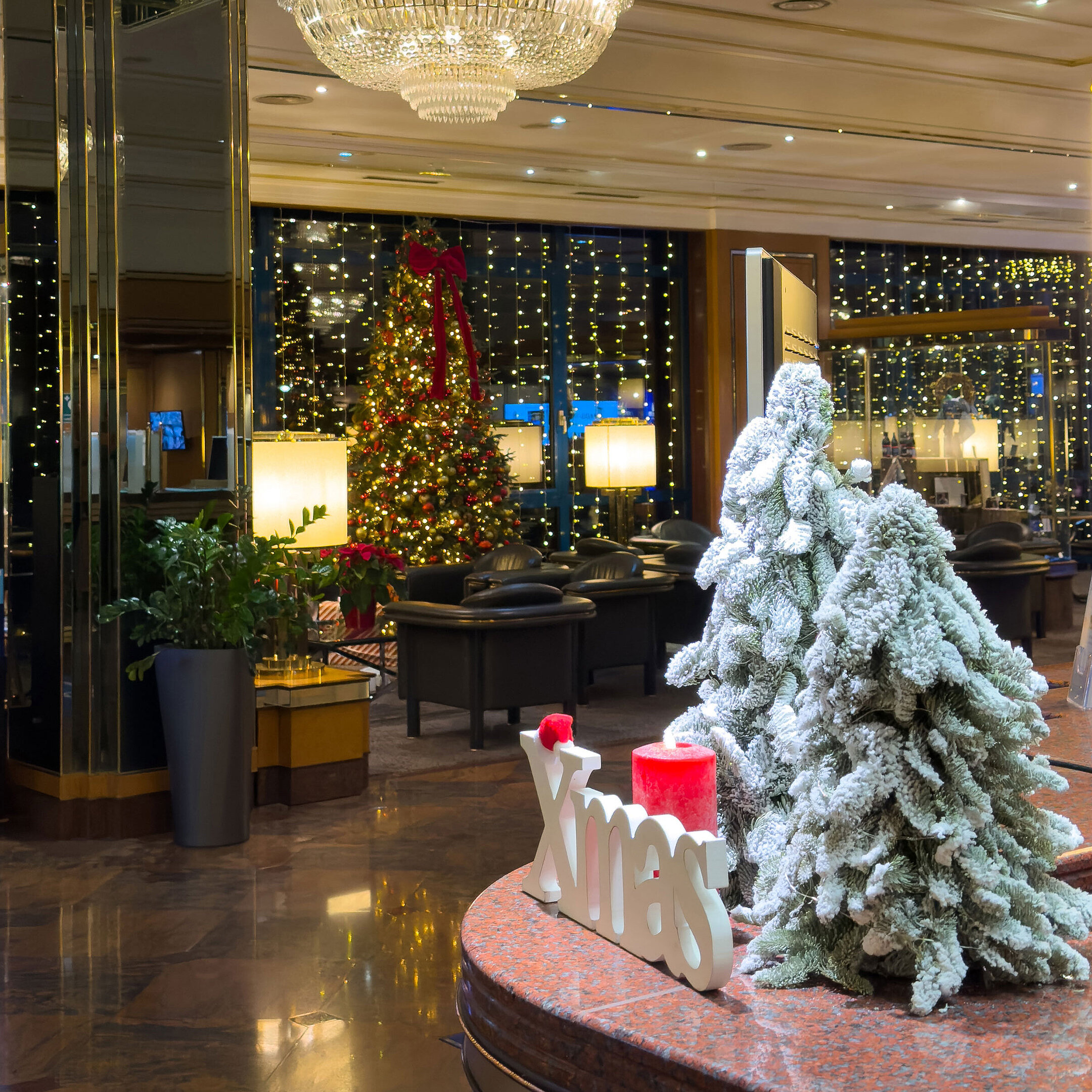 Weihnachtlich geschmückte Hotellobby Festlich dekorierte Hotellobby mit geschmückten Weihnachtsbäumen, Kronleuchter und winterlicher Atmosphäre.