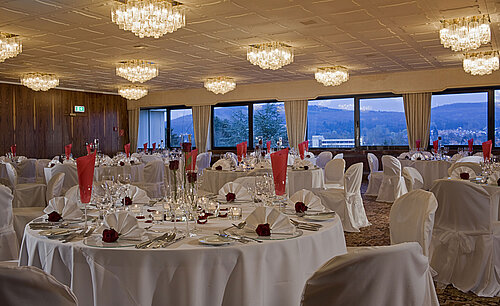 Großer Saal mit runden Tischen, eleganter Deko und Blick ins Grüne im Maritim Hotel Bad Salzuflen