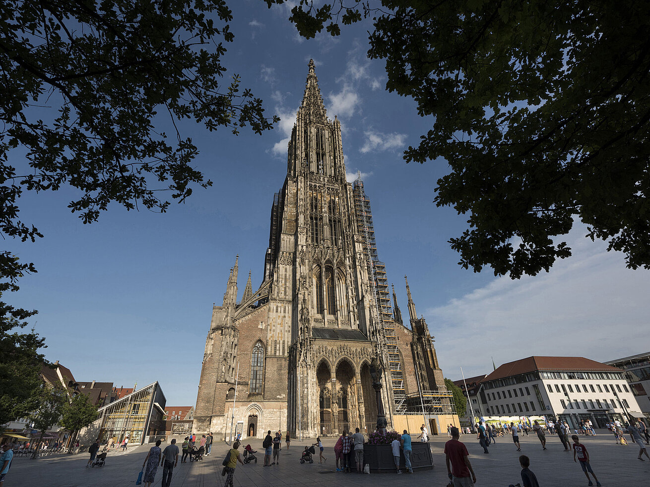 Ulmer Münster Blick auf das imposante Ulmer Münster, die höchste Kirche der Welt, mit Menschen auf dem Münsterplatz.