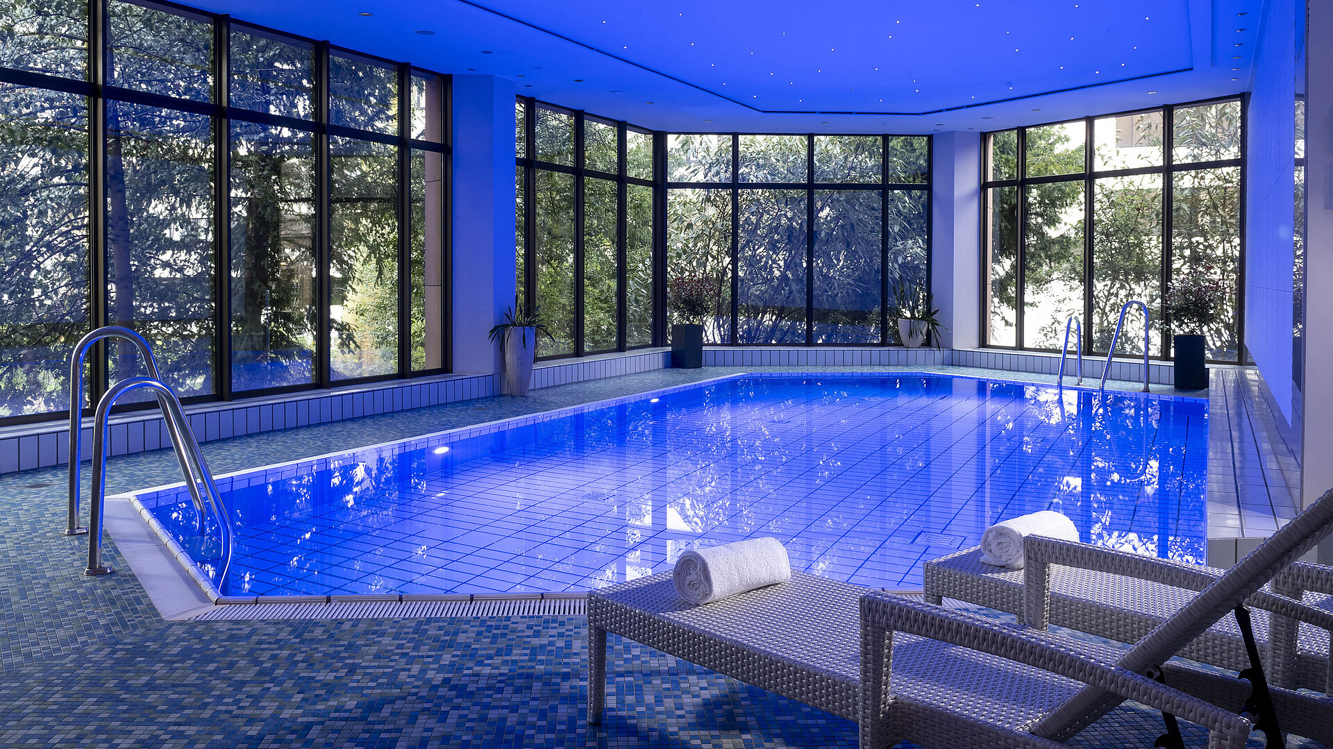 Der stilvolle Innenpool des Maritim Hotel Bad Homburg lädt mit angenehmer Beleuchtung und bequemen Liegen zum Entspannen ein.