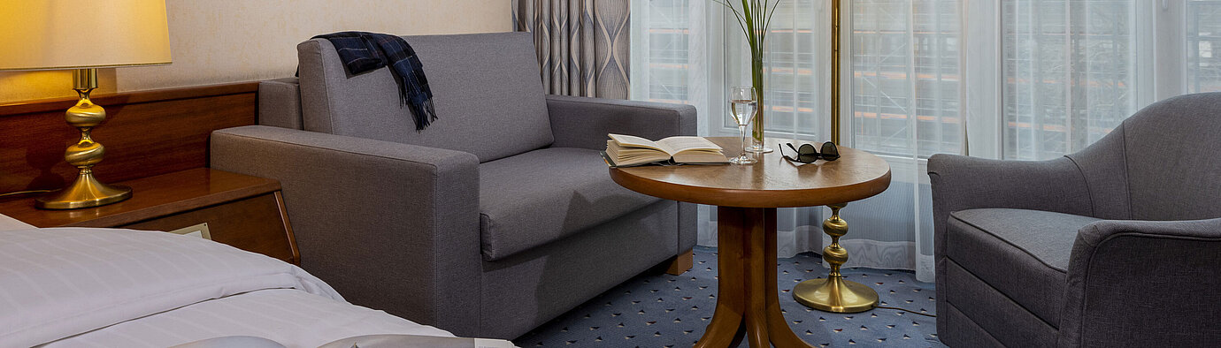Comfort Zimmer im Maritim Hotel Köln, mit gemütlicher Sitzecke, Lesetisch und moderner Einrichtung.