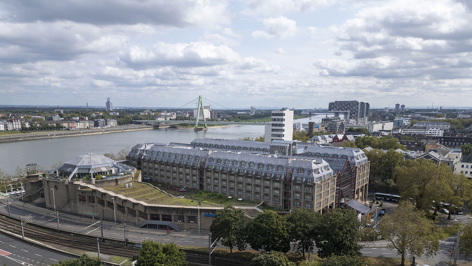 Außenansicht Luftaufnahme des Maritim Hotels Köln, mit Blick auf den Rhein, die Severinsbrücke und umliegende Gebäude.
