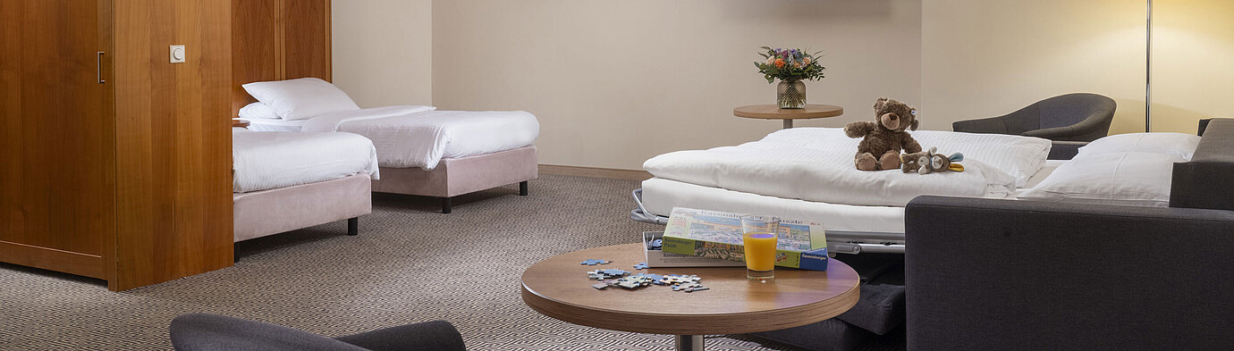 Großes Familienzimmer mit TV, Sofabett, Spielsachen und Puzzle im Maritim Hotel Stuttgart